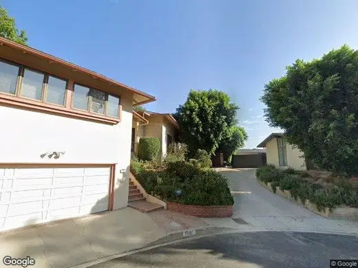 Welcoming exterior of New Spirit Recovery detox center in Los Angeles with lush greenery and a driveway.